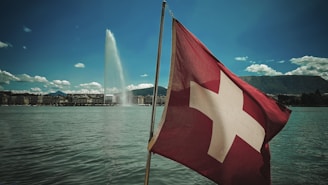 A swiss flag flying in front of a fountain