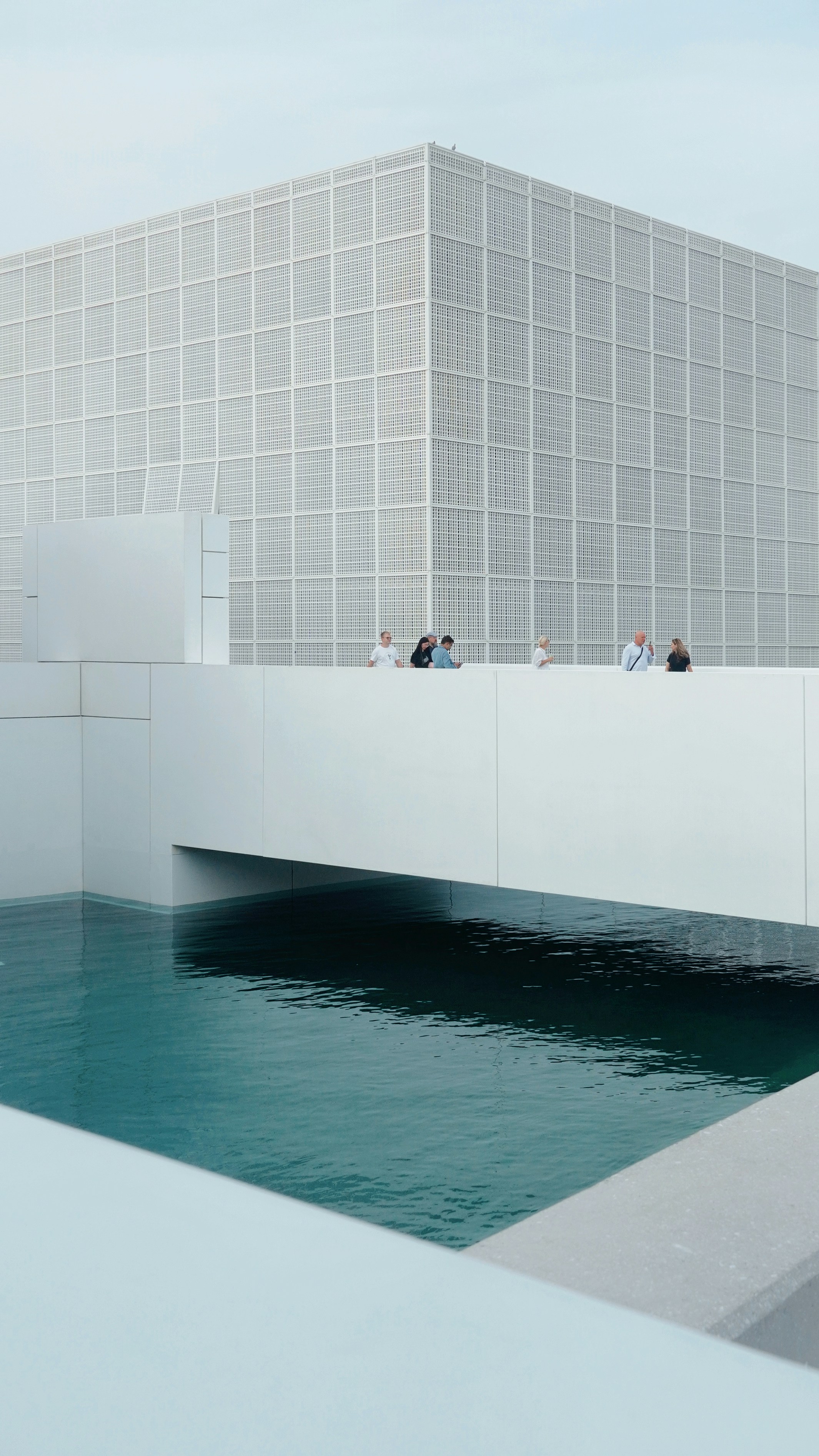 A group of people standing on a bridge over a body of water
