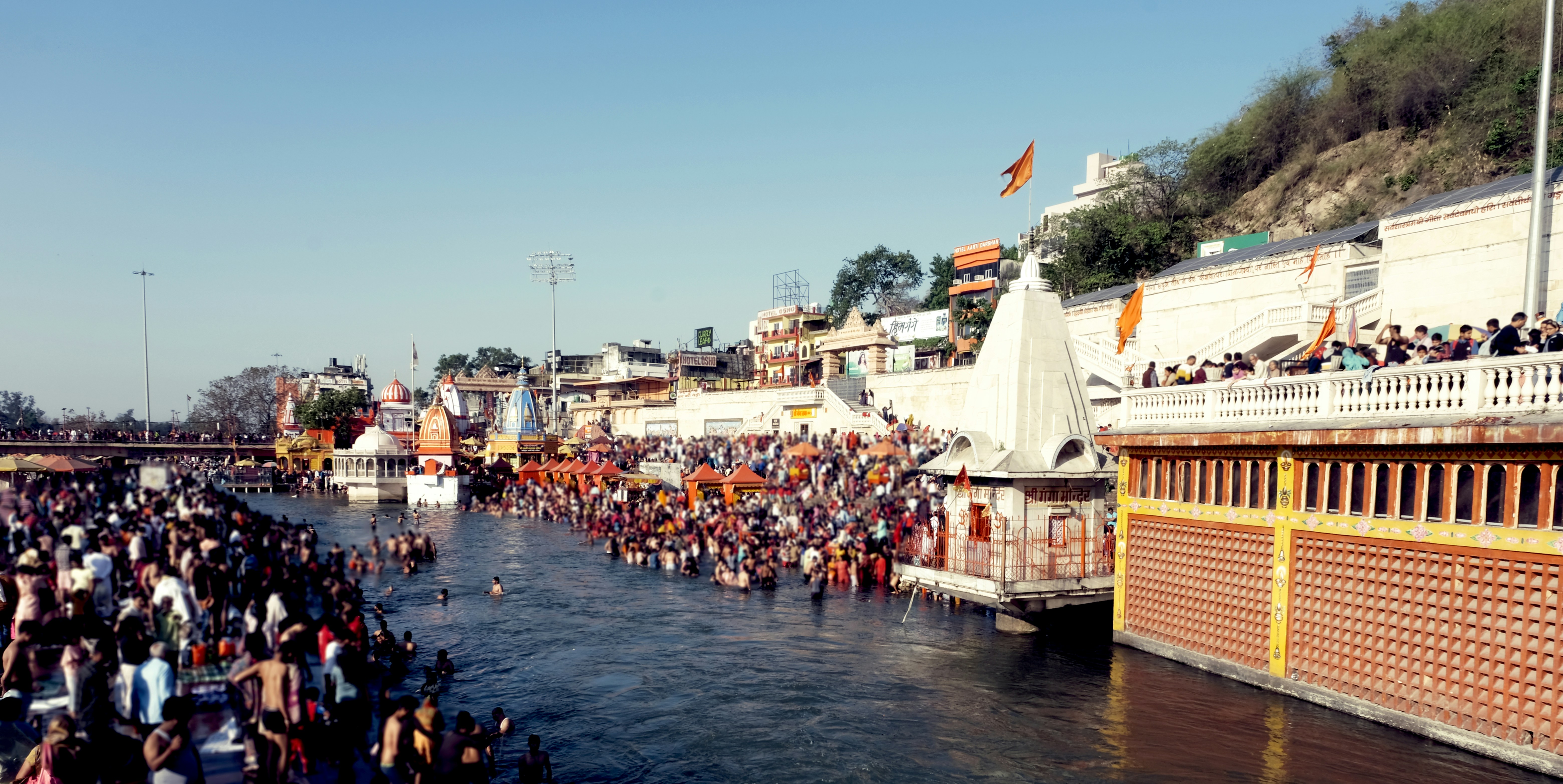 A large group of people standing on the side of a river
