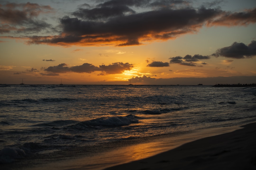 The sun is setting over the ocean on the beach, Waikiki Sunset