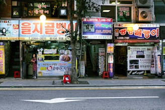 A street scene with a store front and a car parked on the side of the