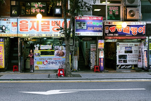 A street scene with a store front and a car parked on the side of the