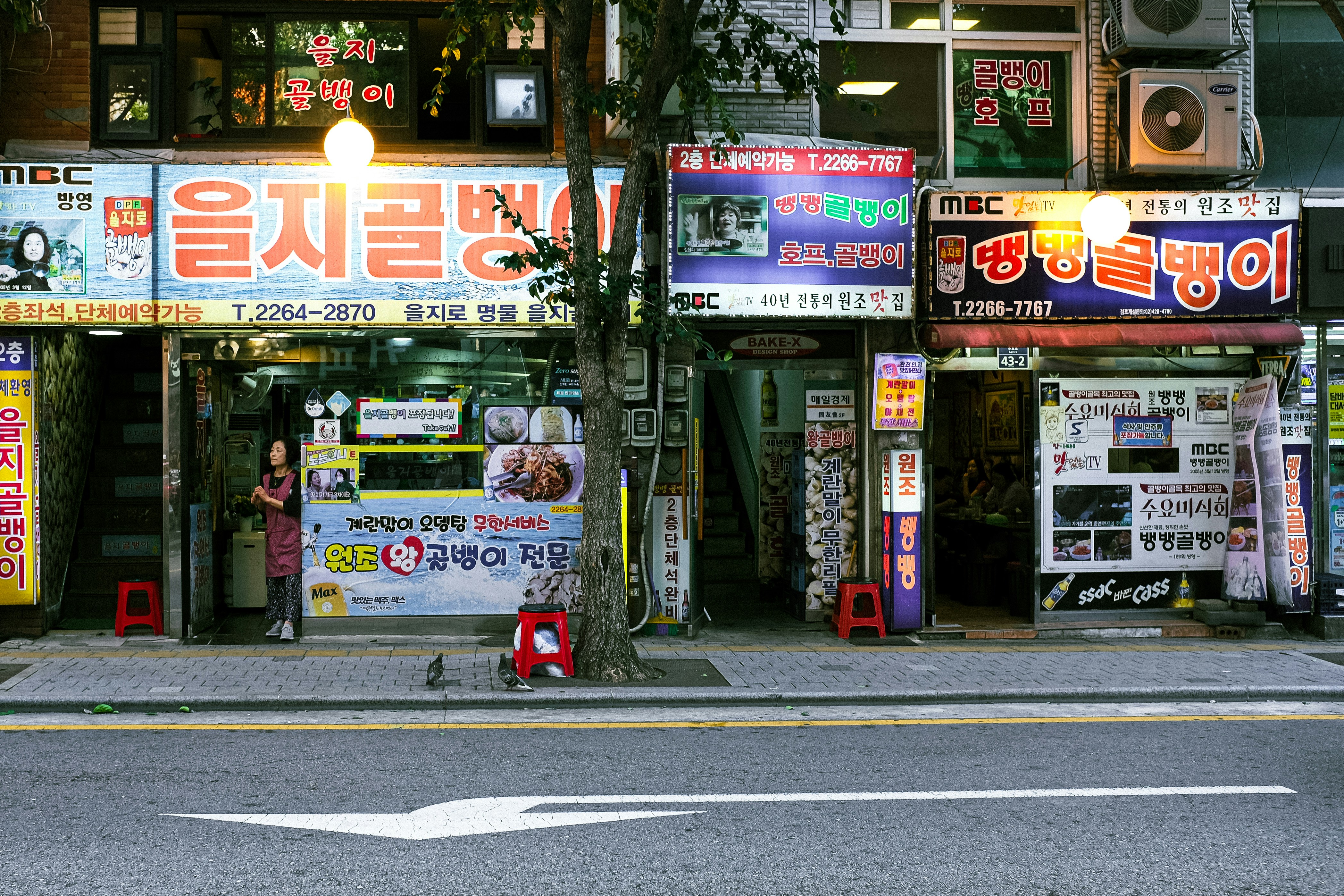 A street scene with a store front and a car parked on the side of the