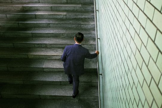 A man in a suit walking up a flight of stairs