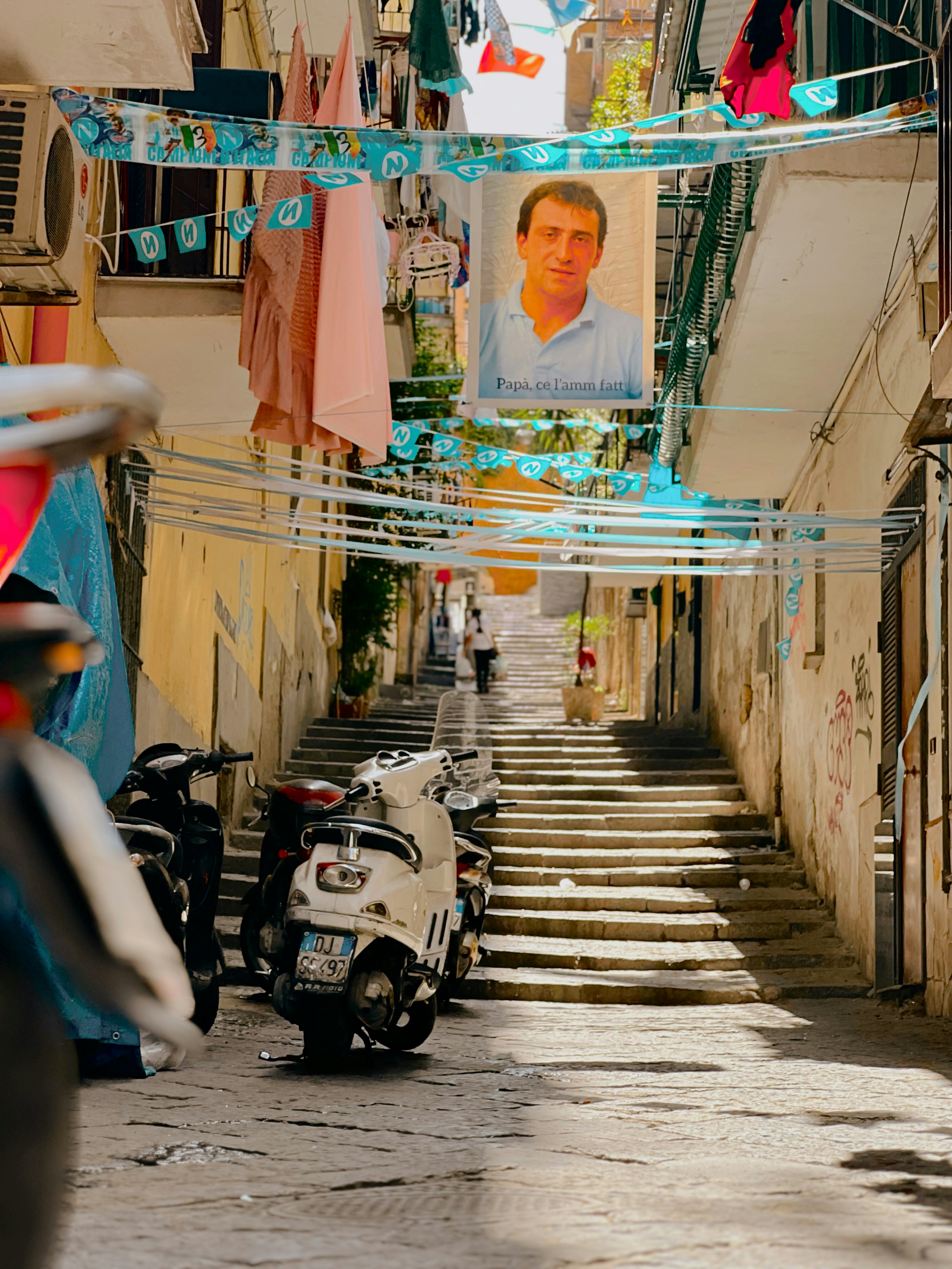 A motor scooter is parked on a narrow street
