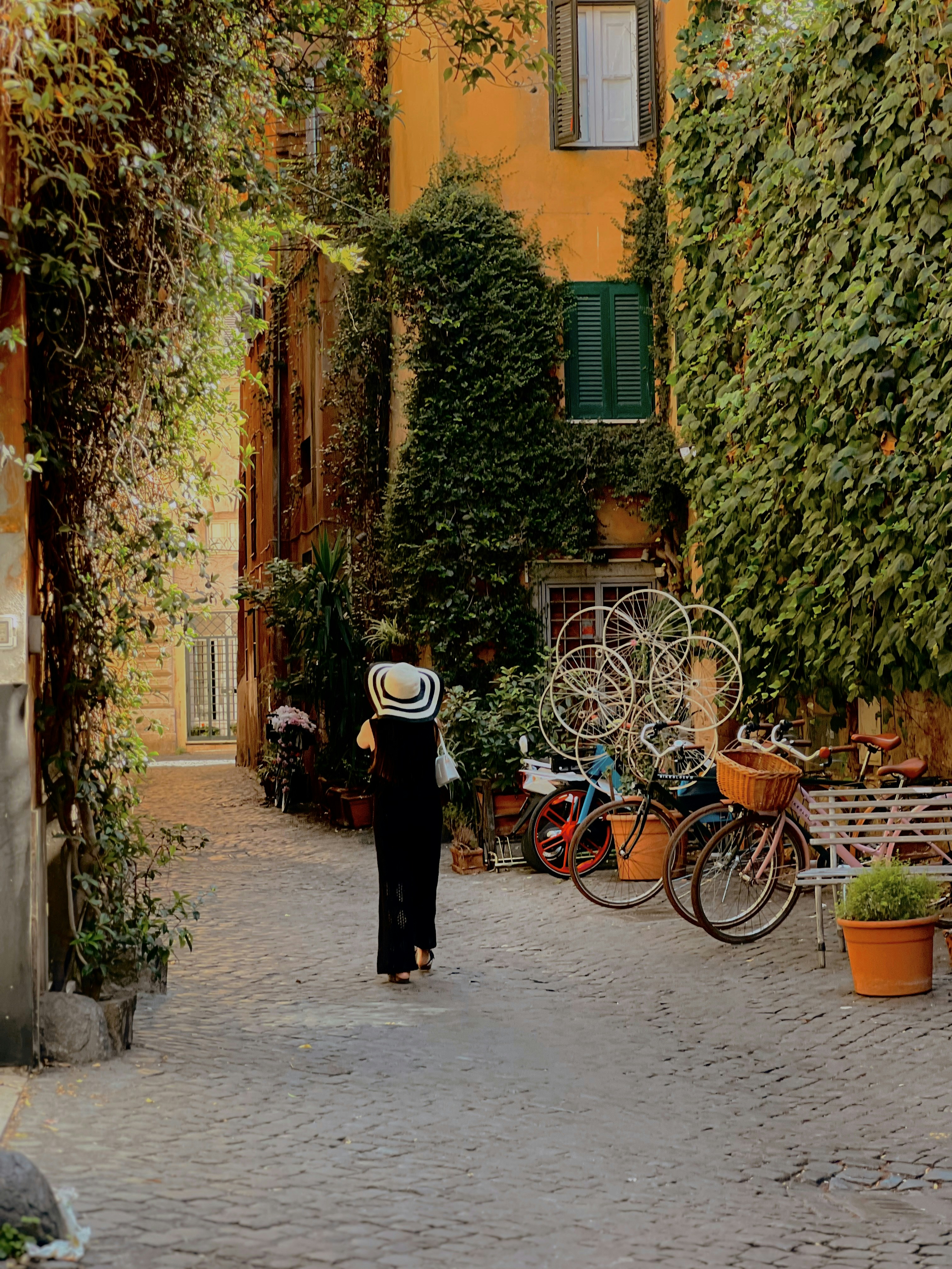 A woman walking down a street carrying a basket on her head