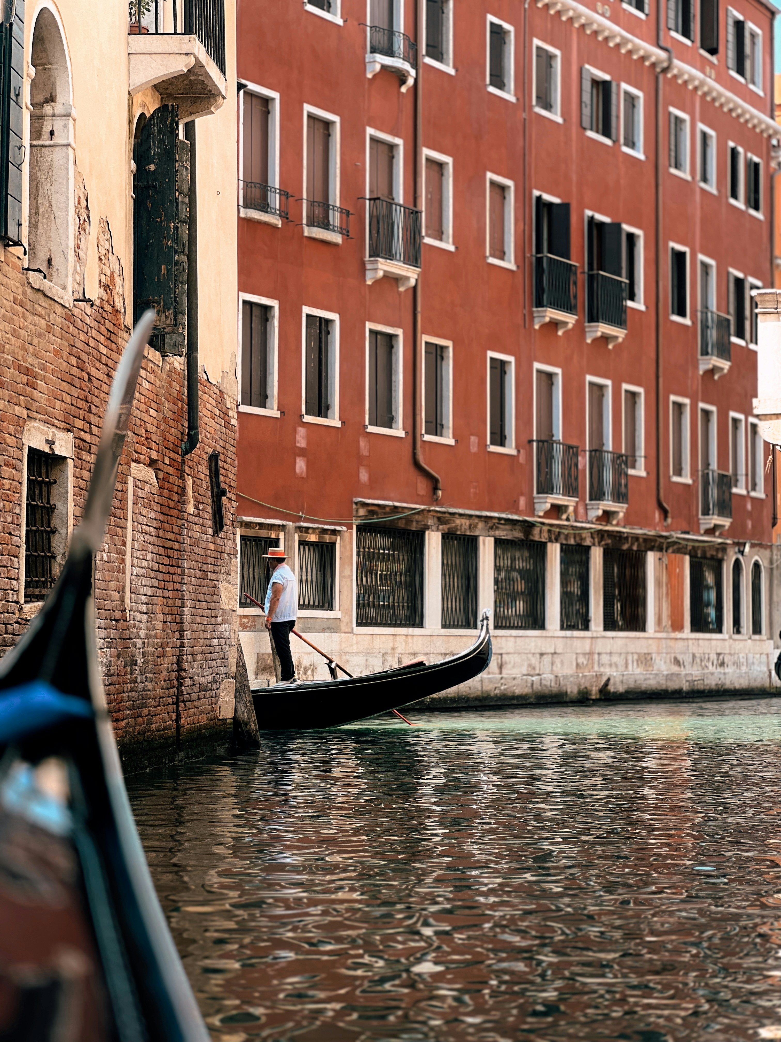 A gondola in a canal with a building in the background