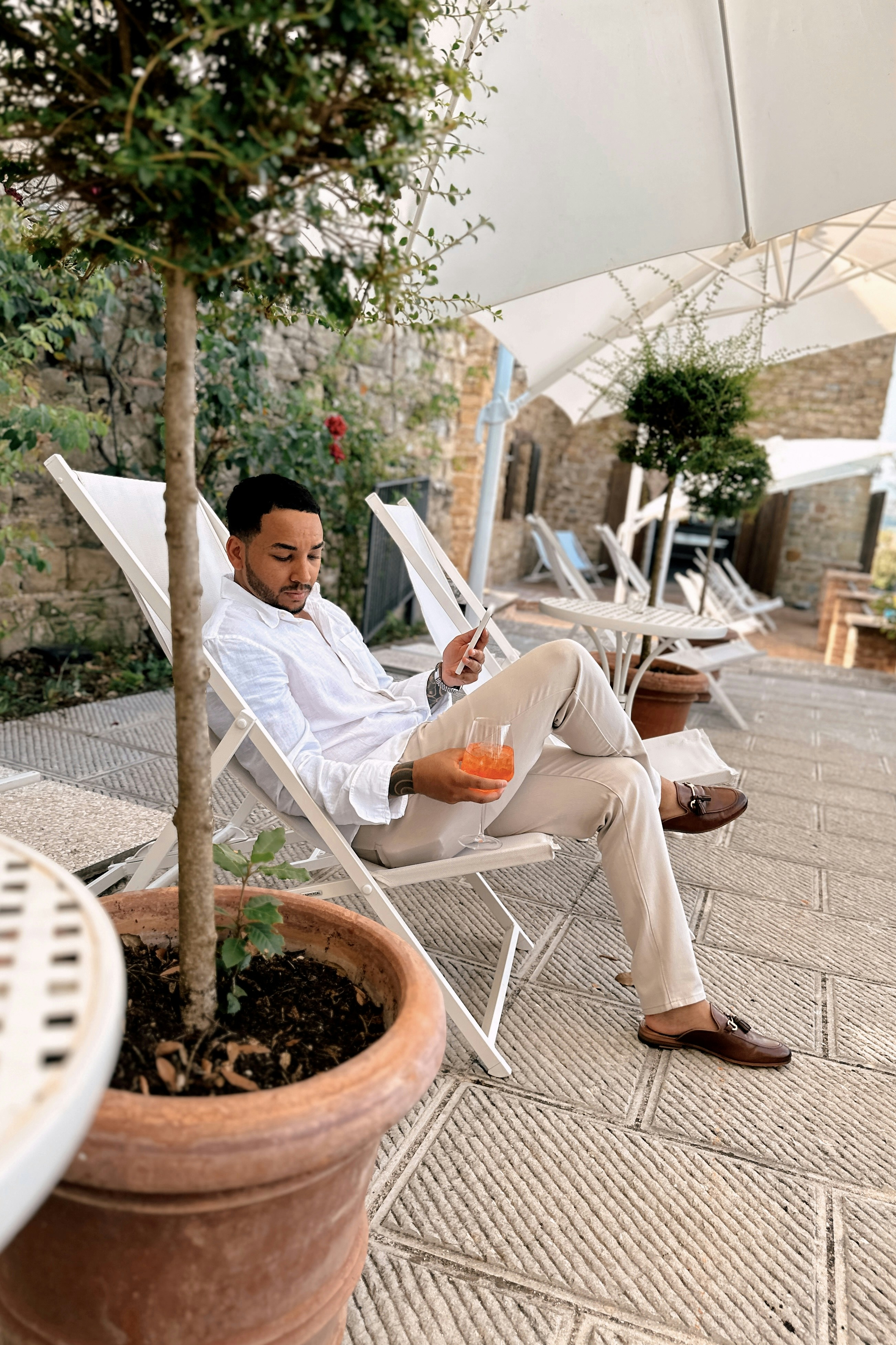 A man sitting in a chair under an umbrella