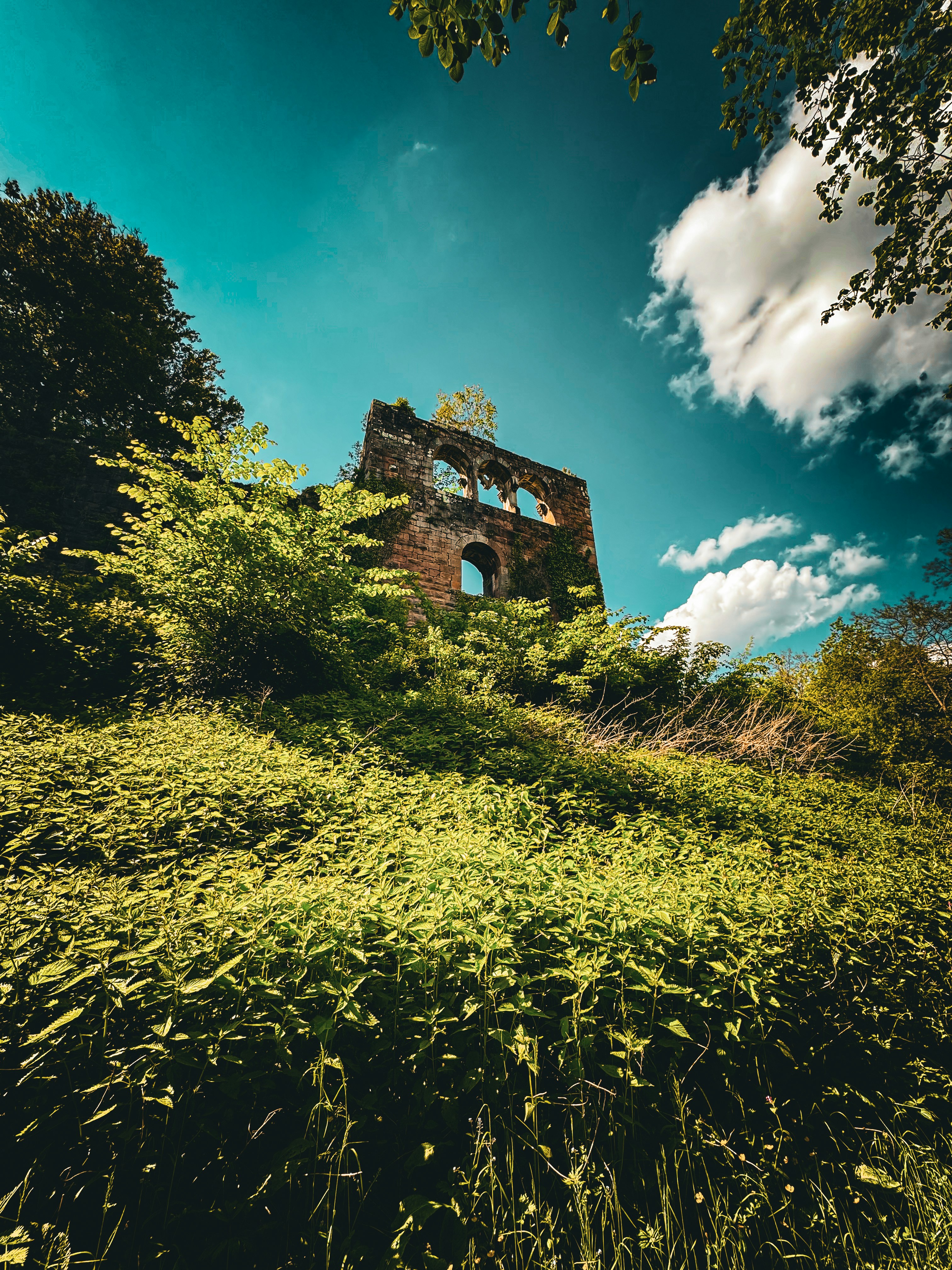 An old building sitting on top of a lush green hillside