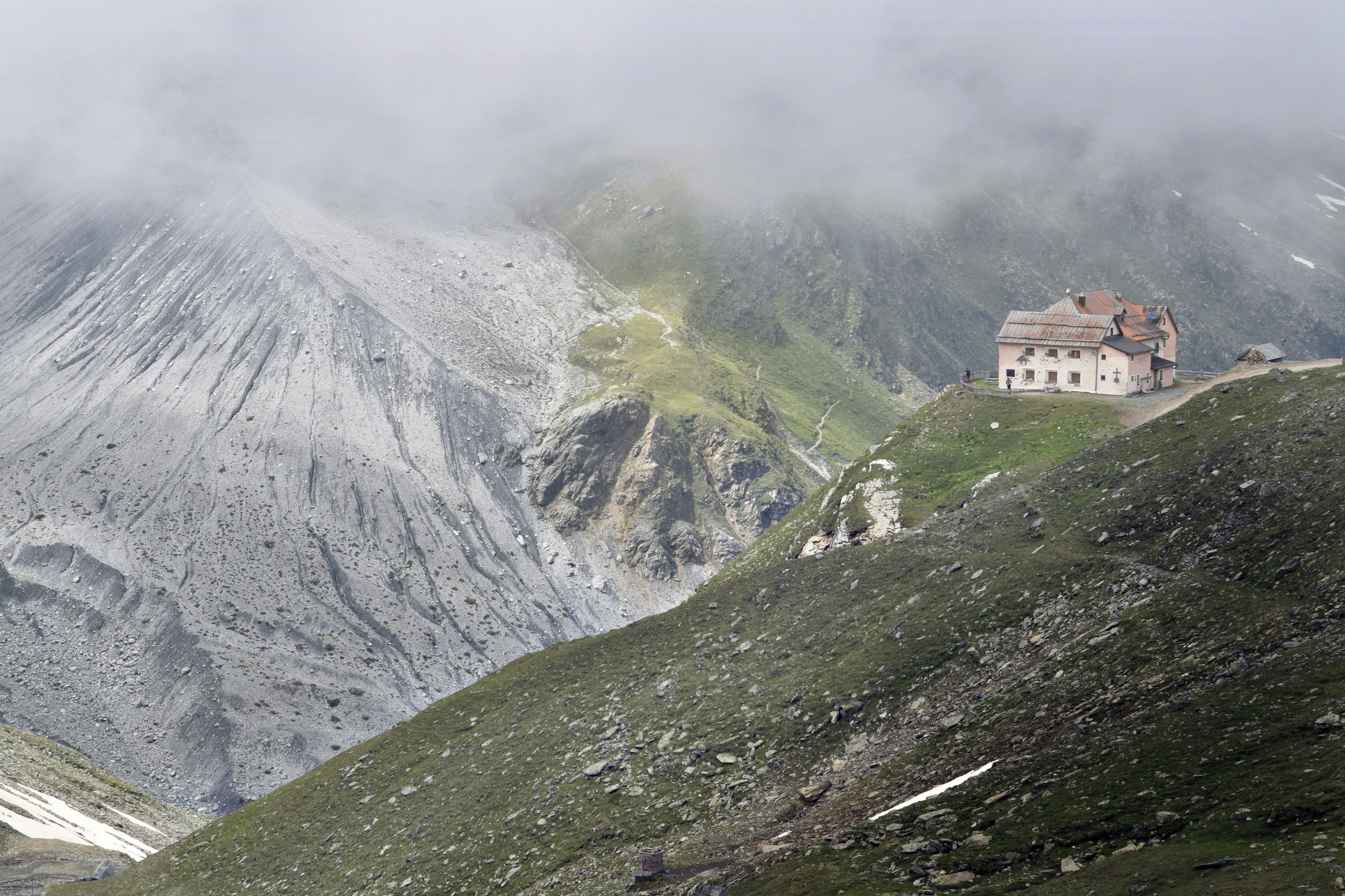 A house on top of a mountain surrounded by clouds