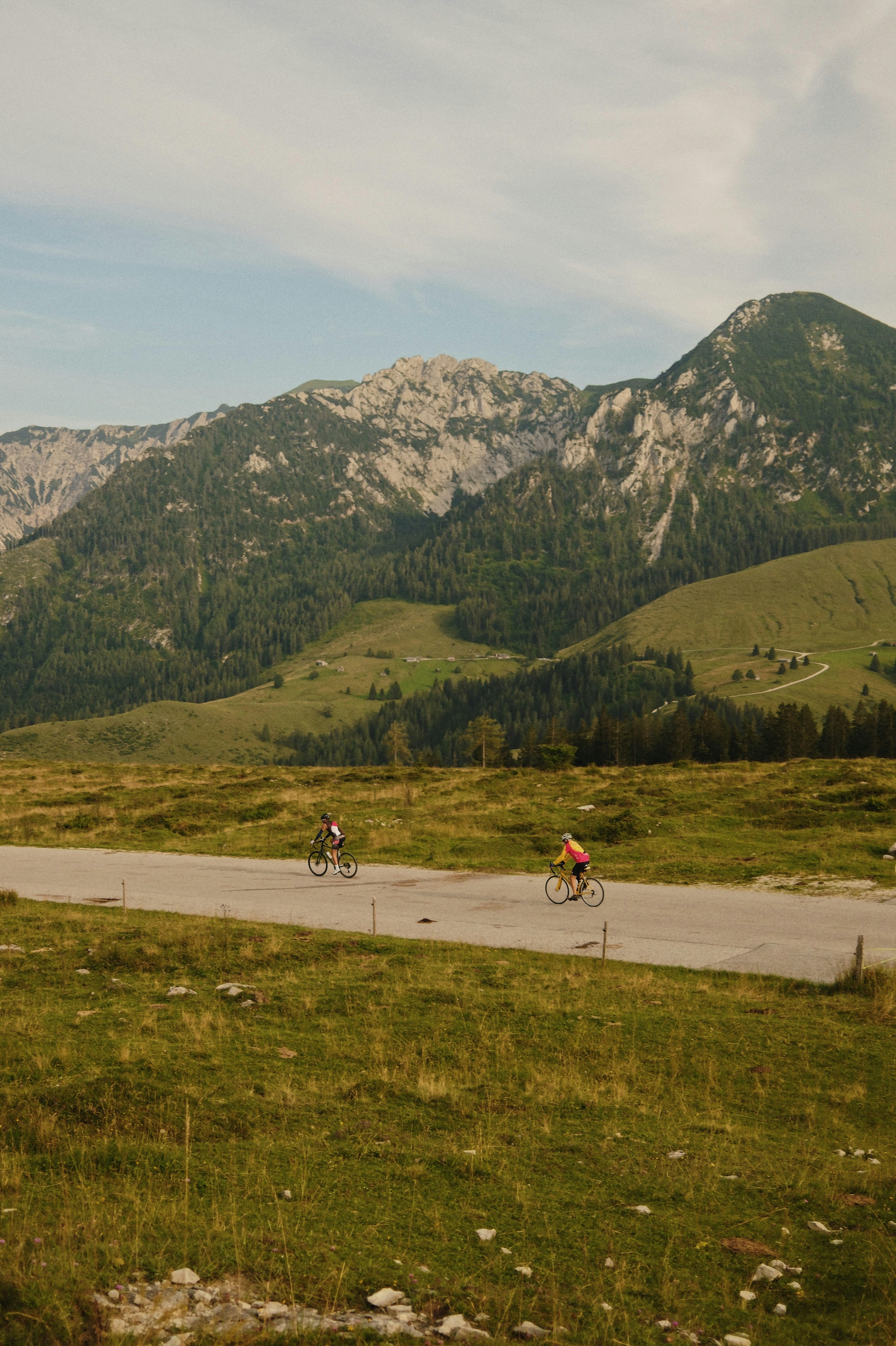 A couple of people riding bikes down a road