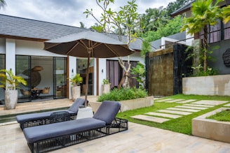 A patio with a lawn and a lounge chair