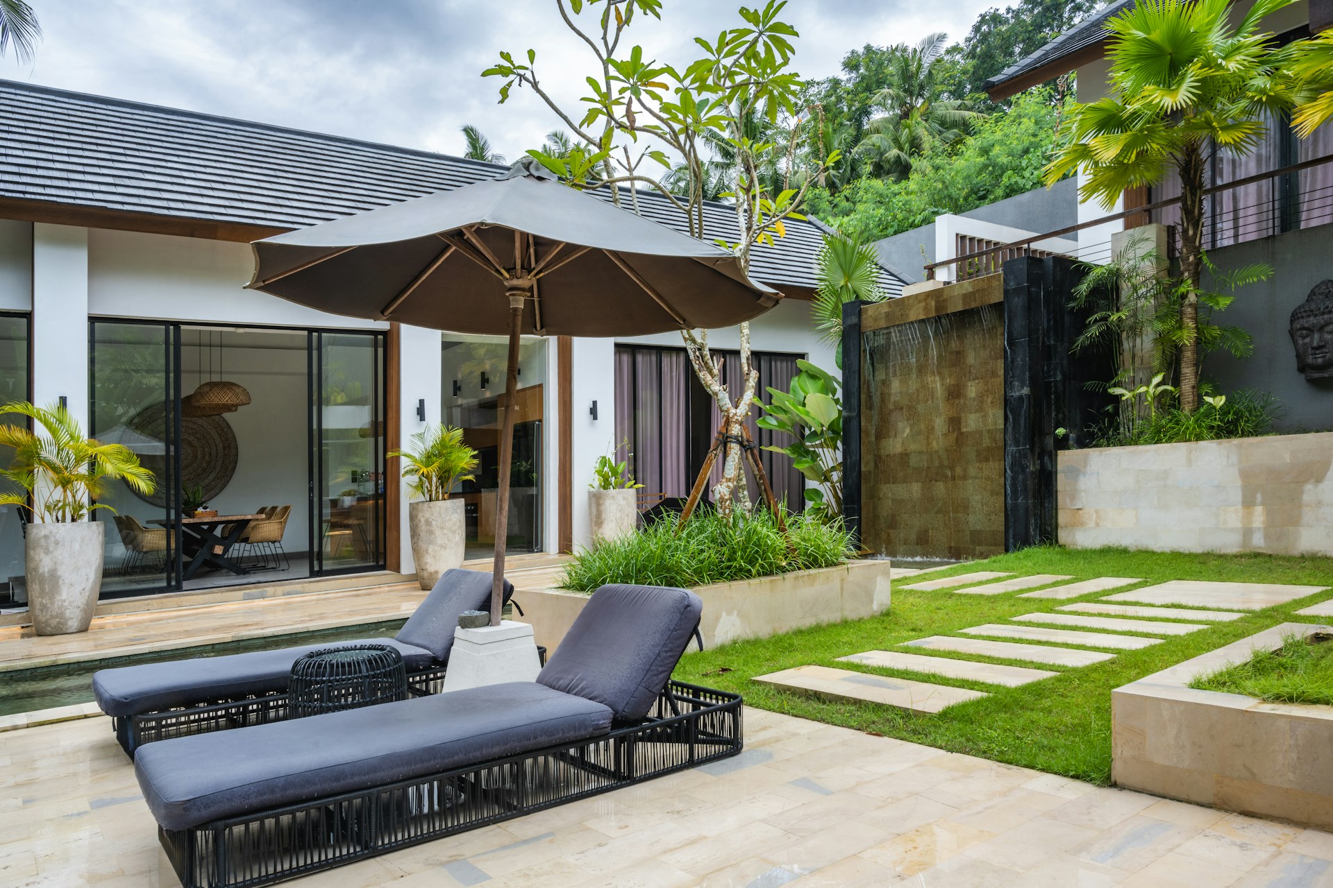 A patio with a lawn and a lounge chair