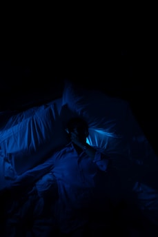 A person laying in a bed in a dark room
