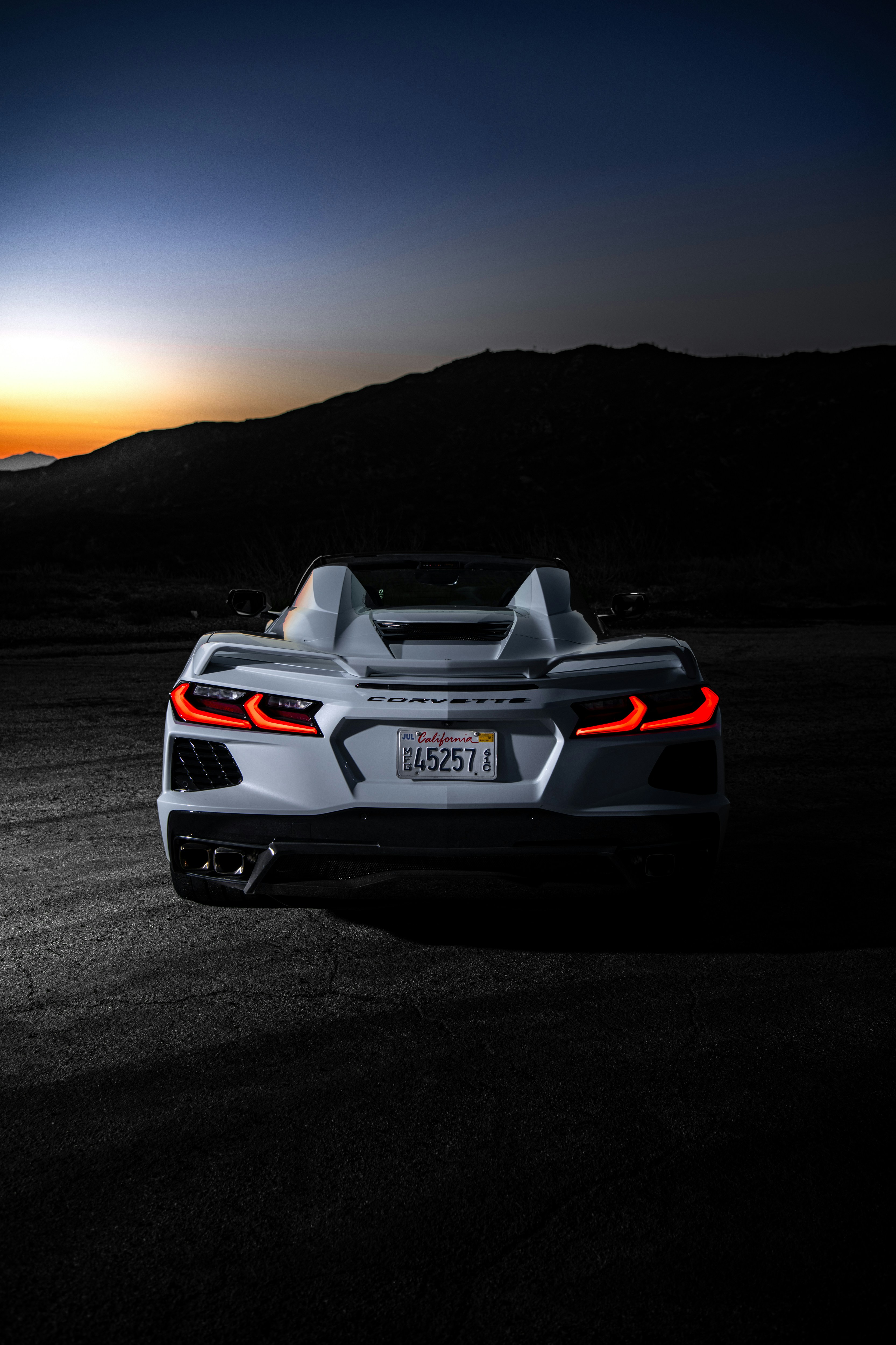 A white sports car parked in the middle of a field