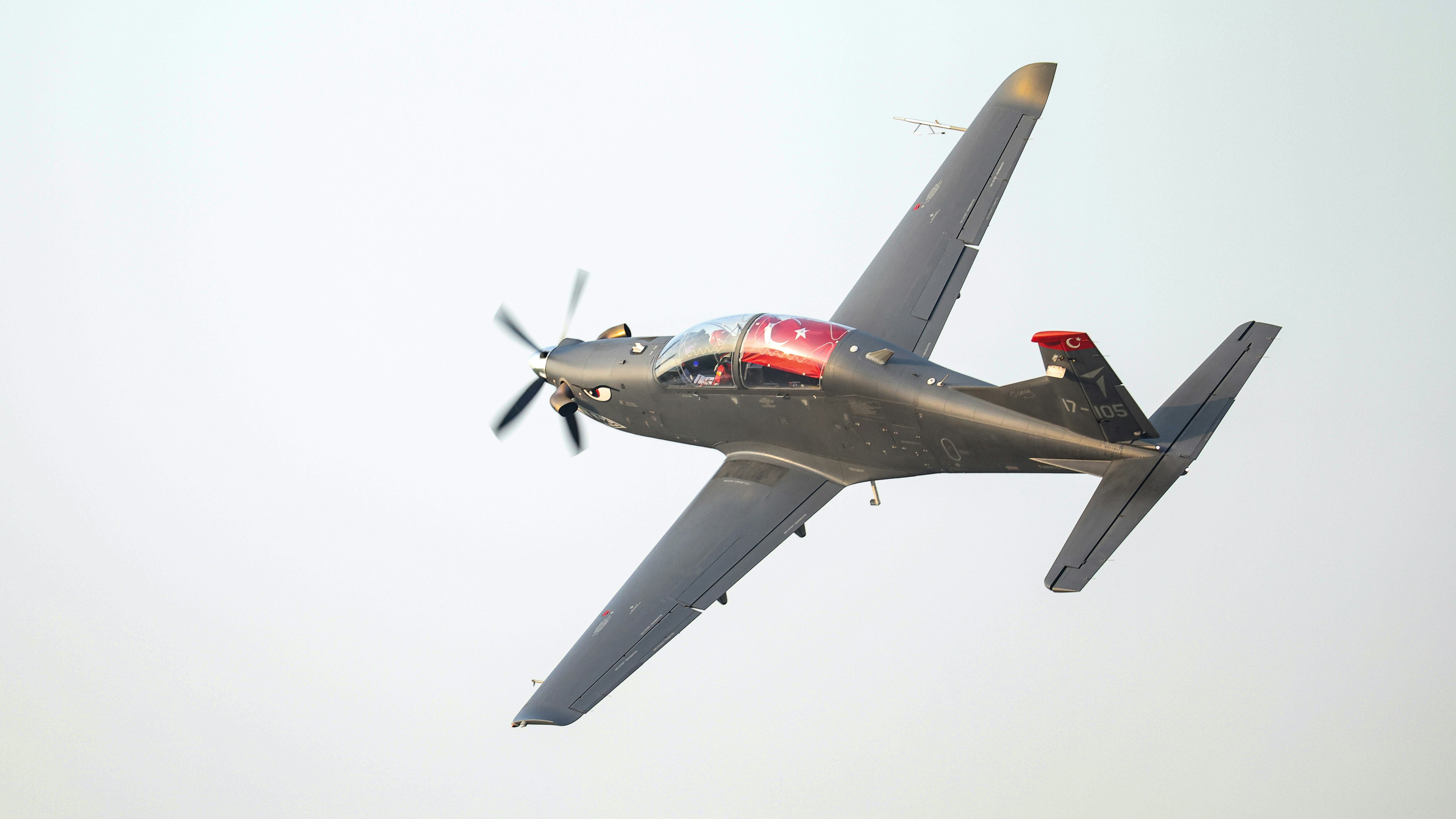A fighter jet flying through the sky on a clear day, Hürkuş in demonstration flight.