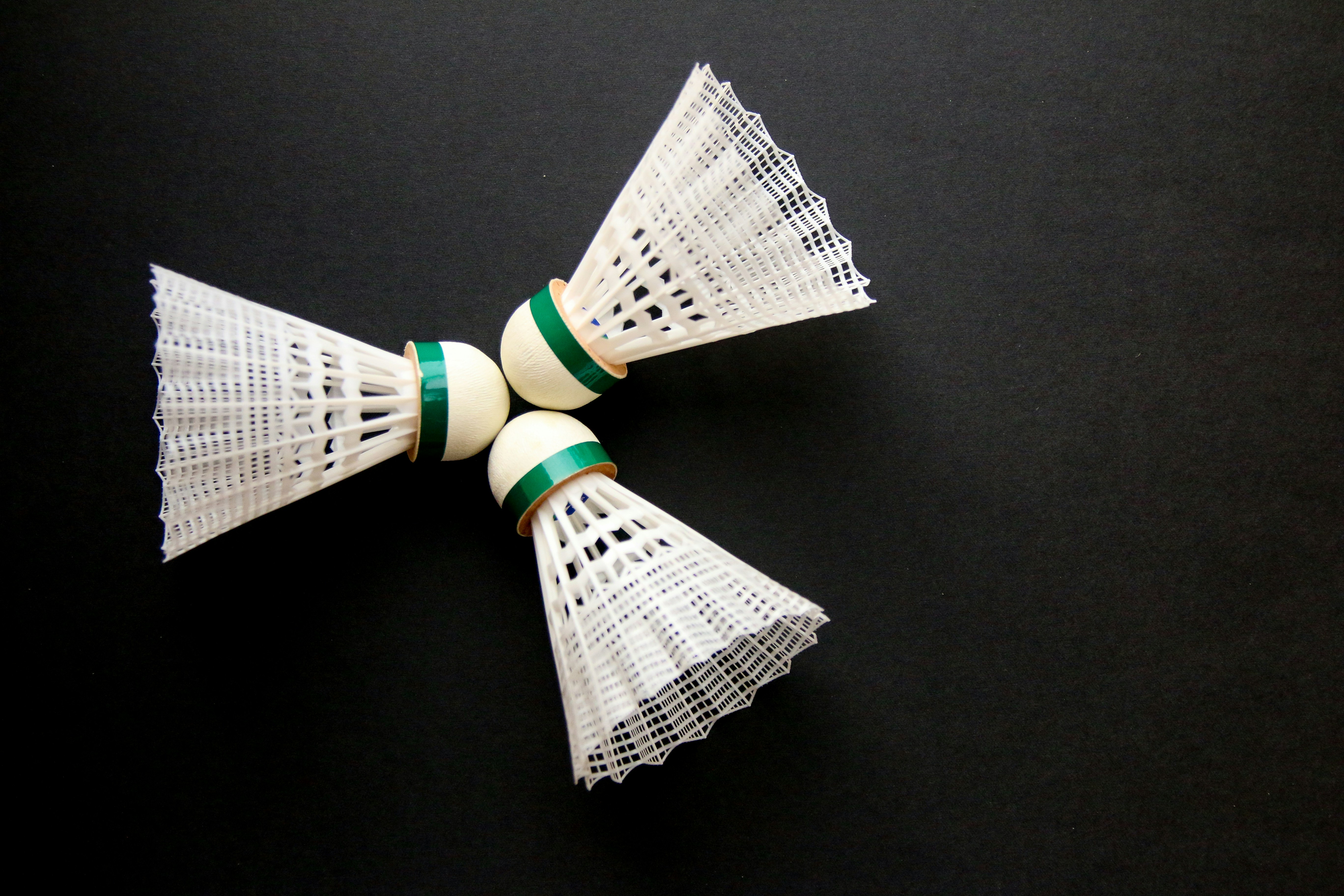 A close up of two white and green bows on a black surface
