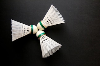 A close up of two white and green bows on a black surface