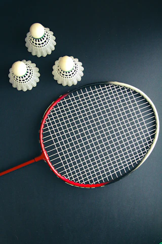 A tennis racket and four balls on a table