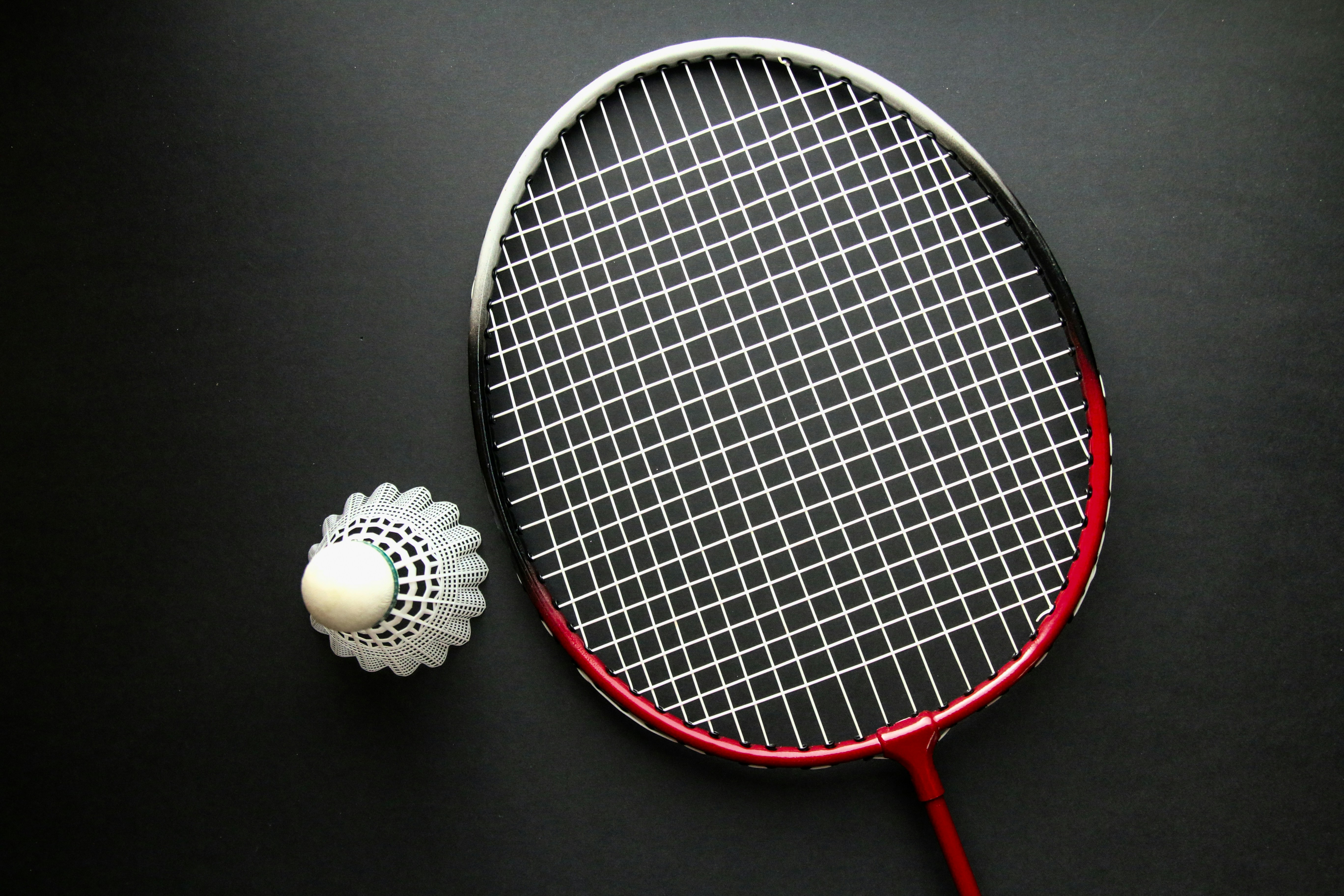 Une raquette de tennis et une balle sur une surface noire