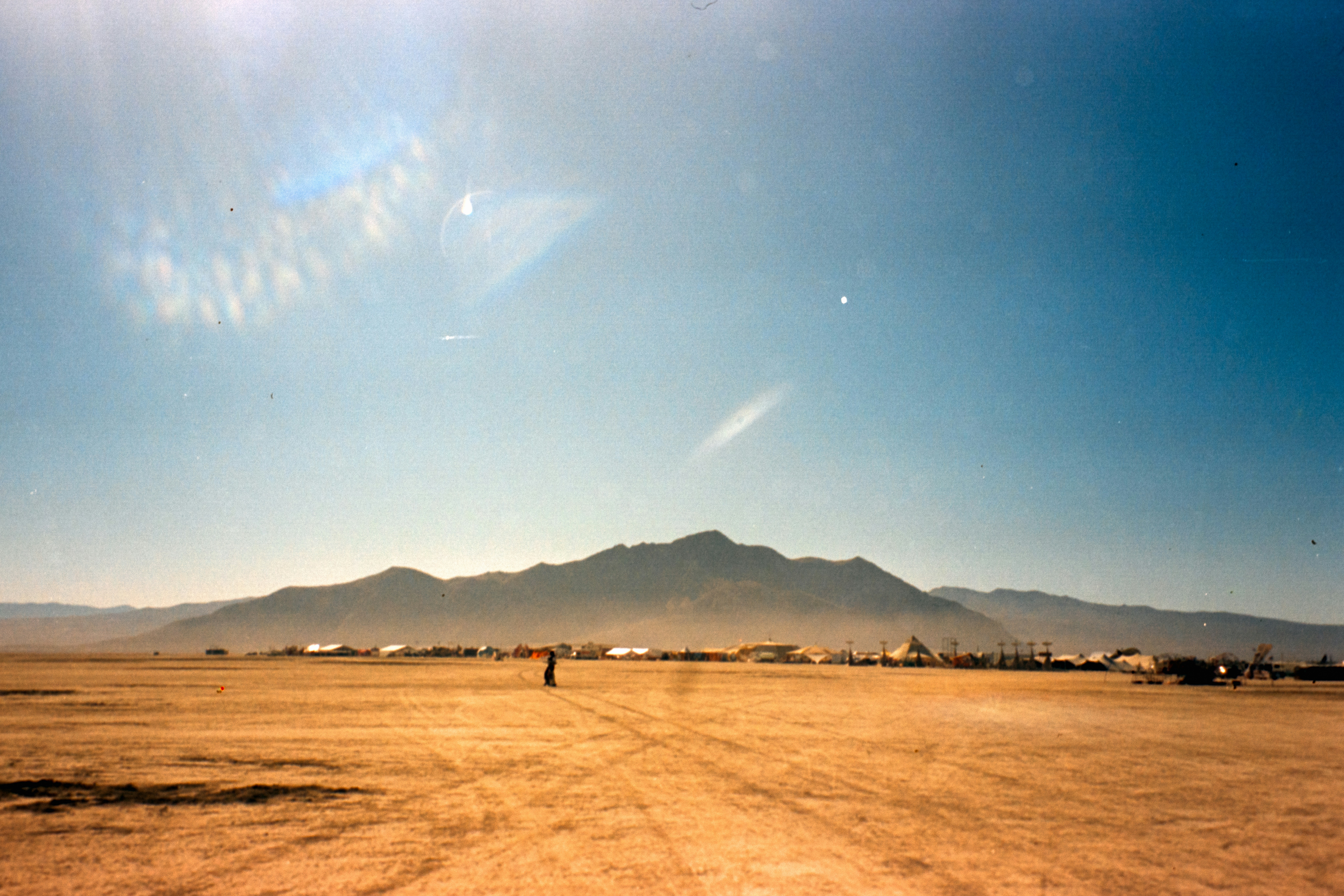 A dirt road with a mountain in the background