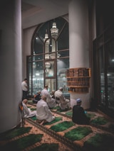 A group of men sitting on the floor of a building