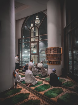 A group of men sitting on the floor of a building