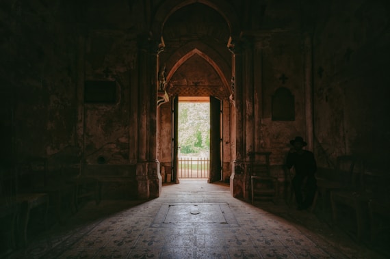 A dark hallway with an open door leading to another room