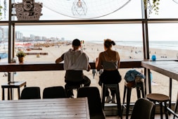 A couple of people sitting at a table in front of a window