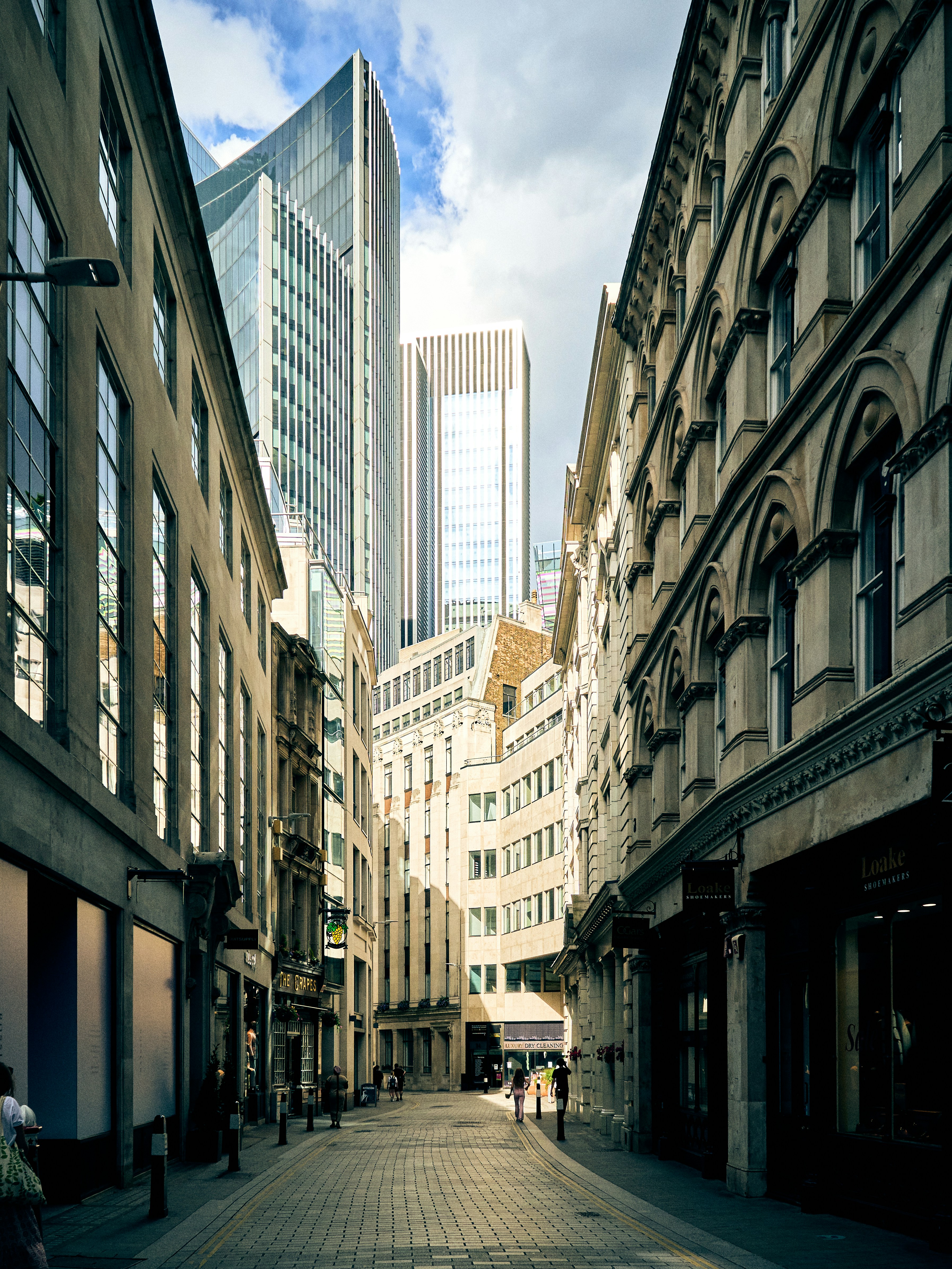 A narrow city street lined with tall buildings photo – Free City Image ...