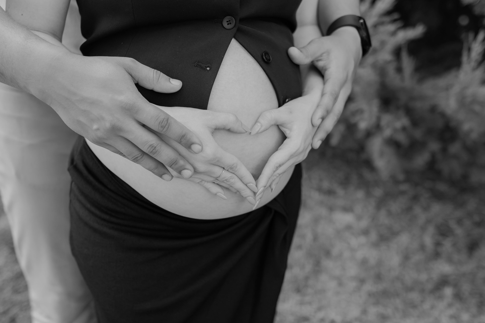 A pregnant woman holding her stomach in a black and white photo