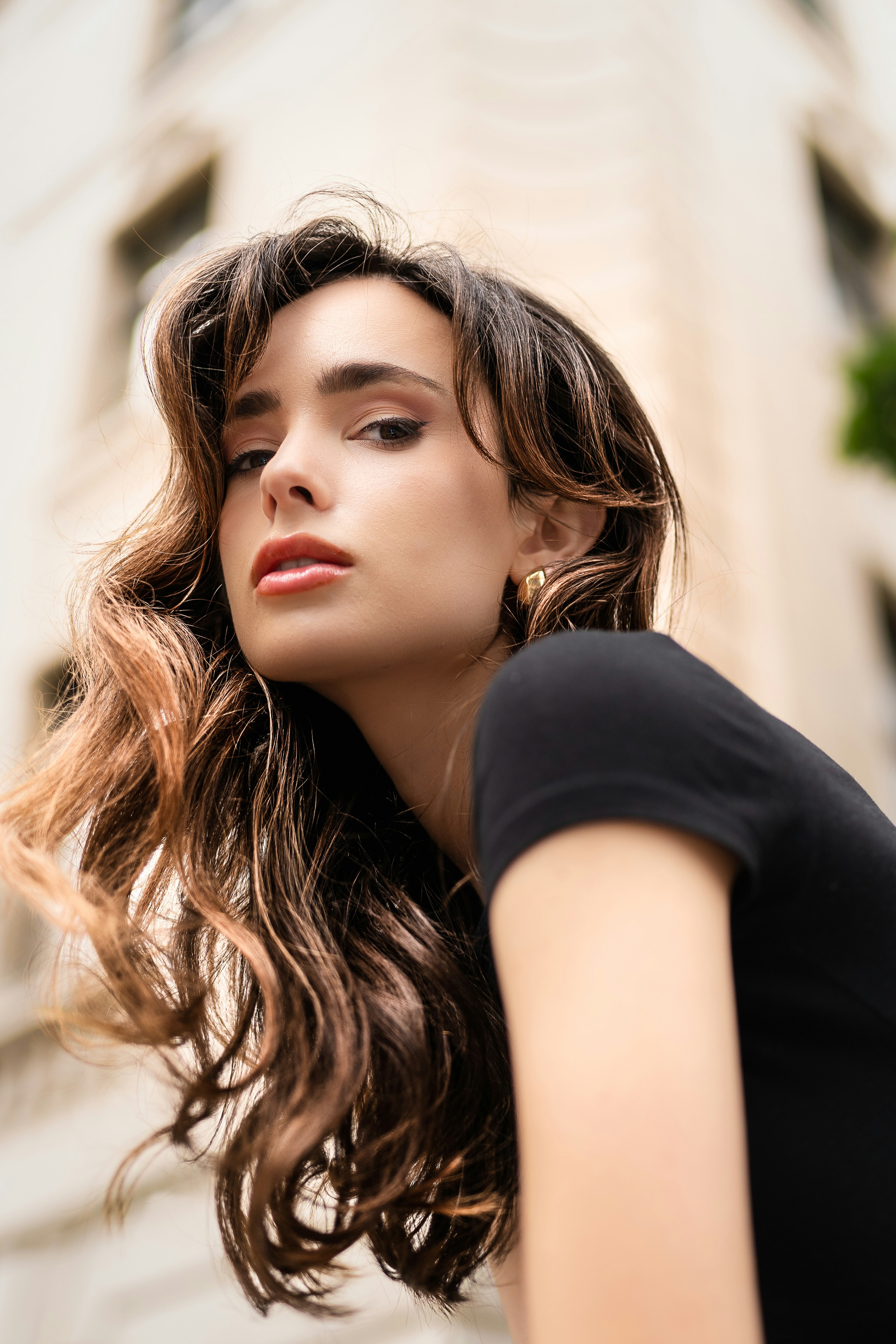 A woman with long hair standing in front of a building