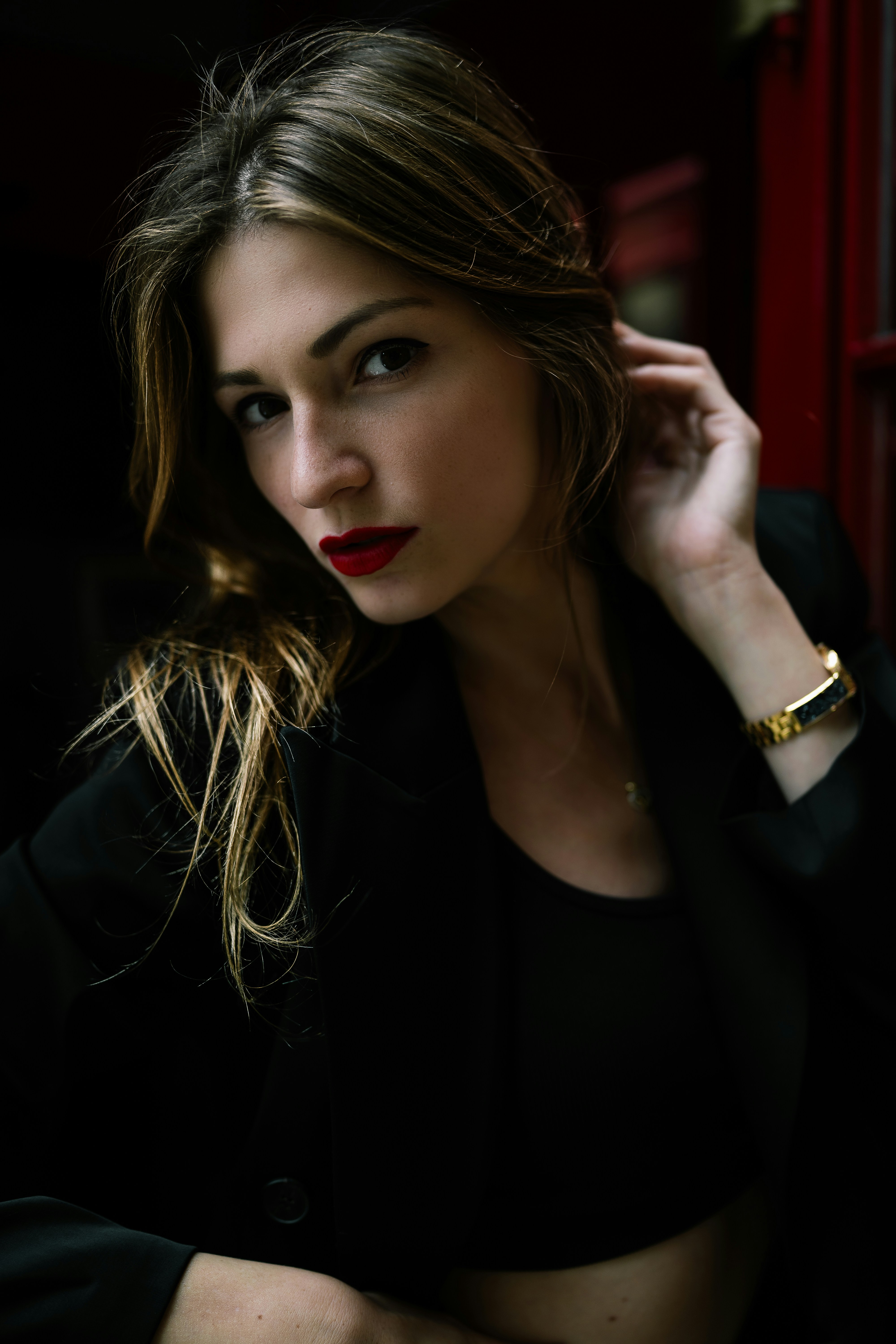 A woman in a black suit and red lipstick