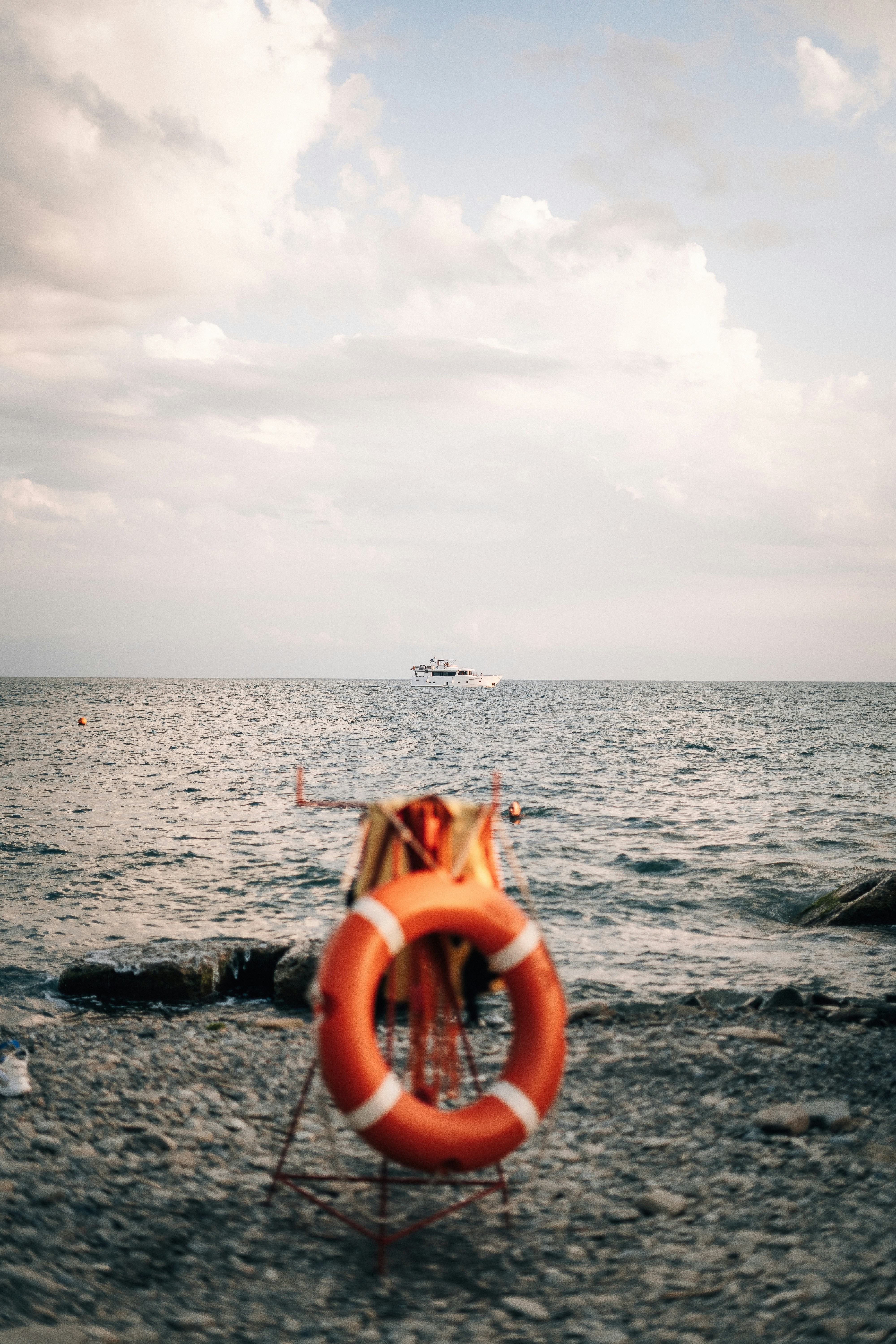 A life preserver on a beach with a boat in the background
