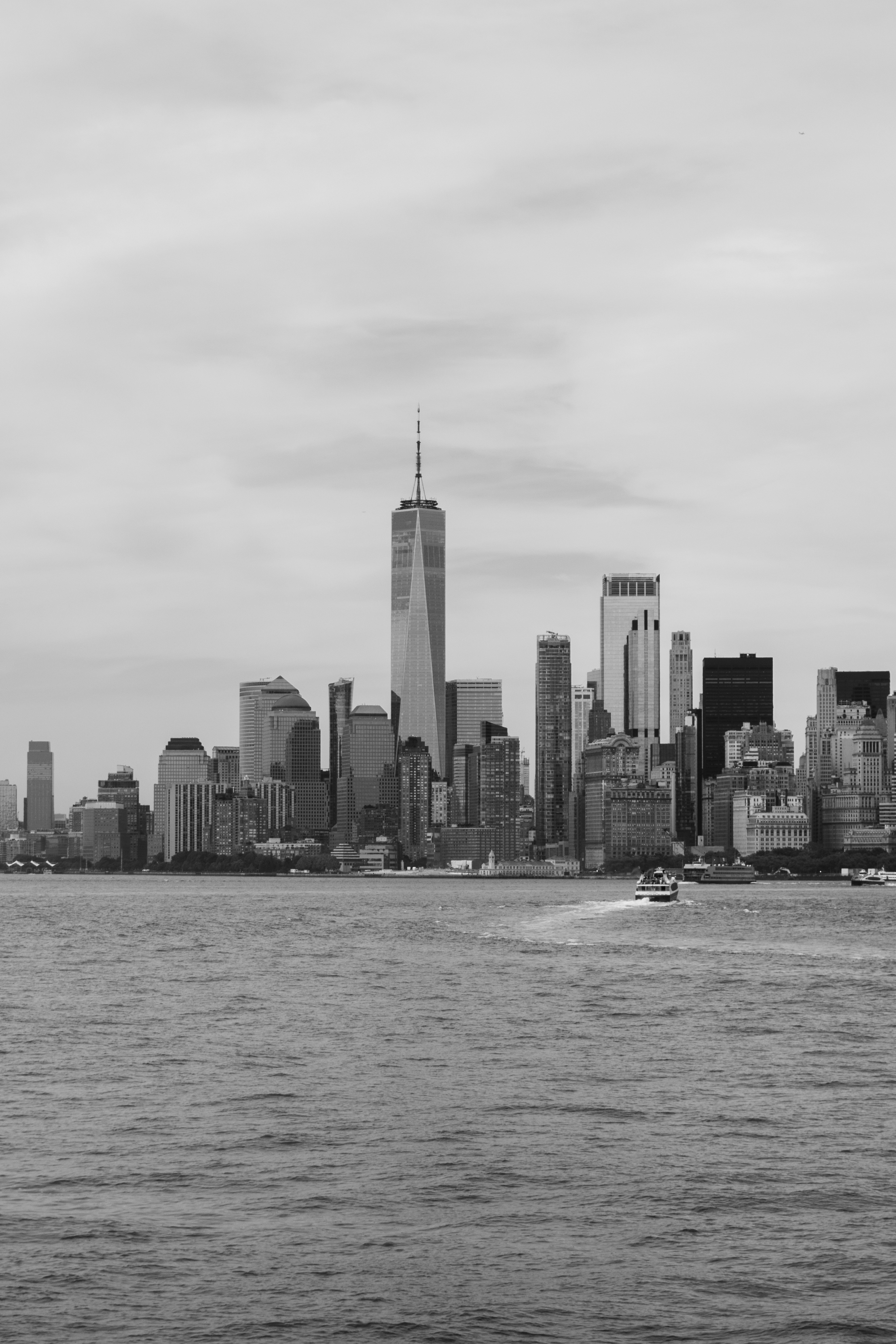 The tip of the lower Manhattan New York City skyline as seen from the Staten Island Ferry in New York City Harbor. The skyline features the Whitehall Building and One World Trade Center.