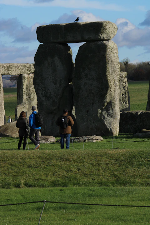 A group of people standing in front of a stonehenge