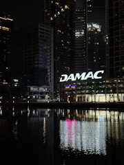 A view of a city at night with a sign that says damac