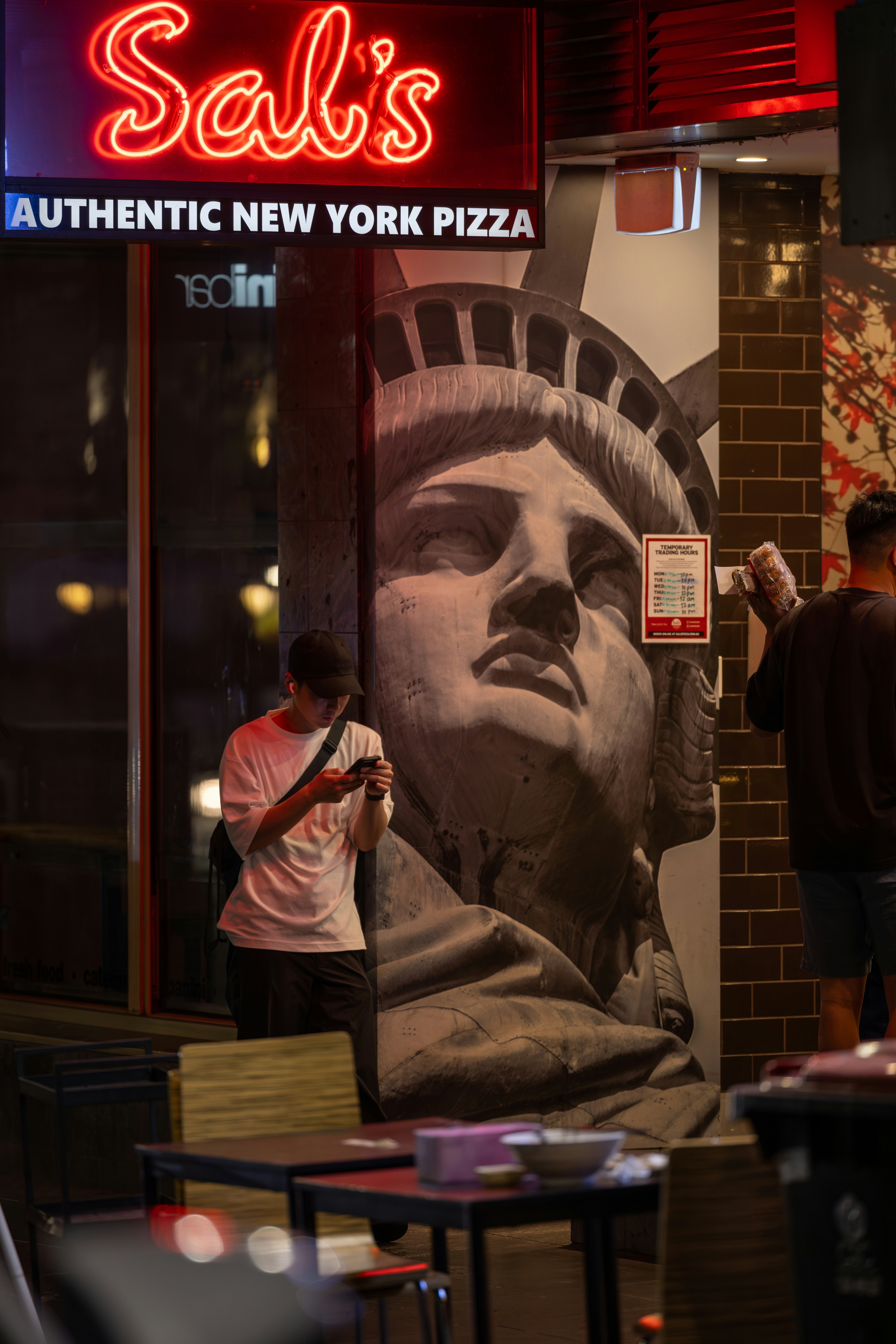 A man taking a picture of a statue of liberty