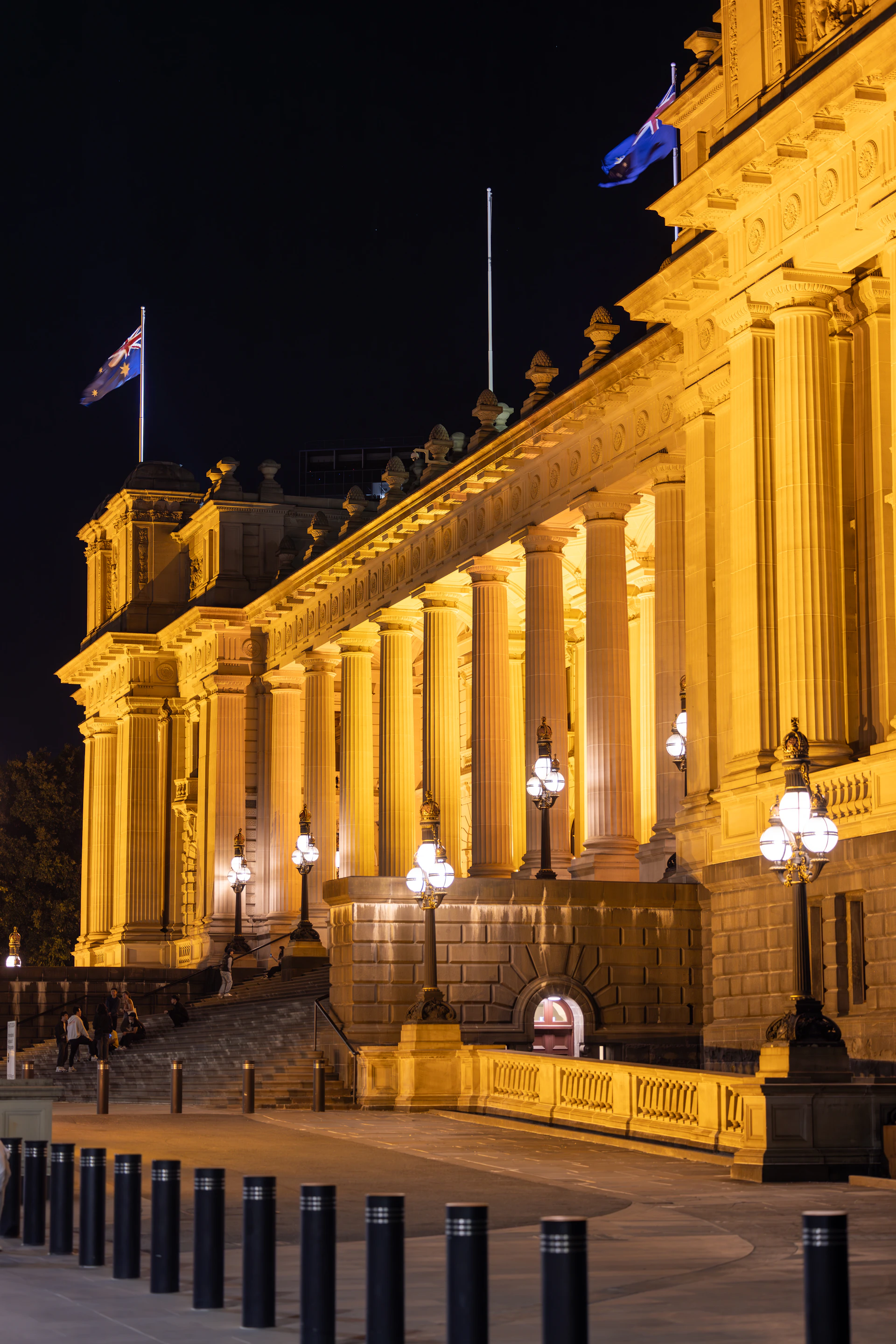 A large building with columns and flags on top of it