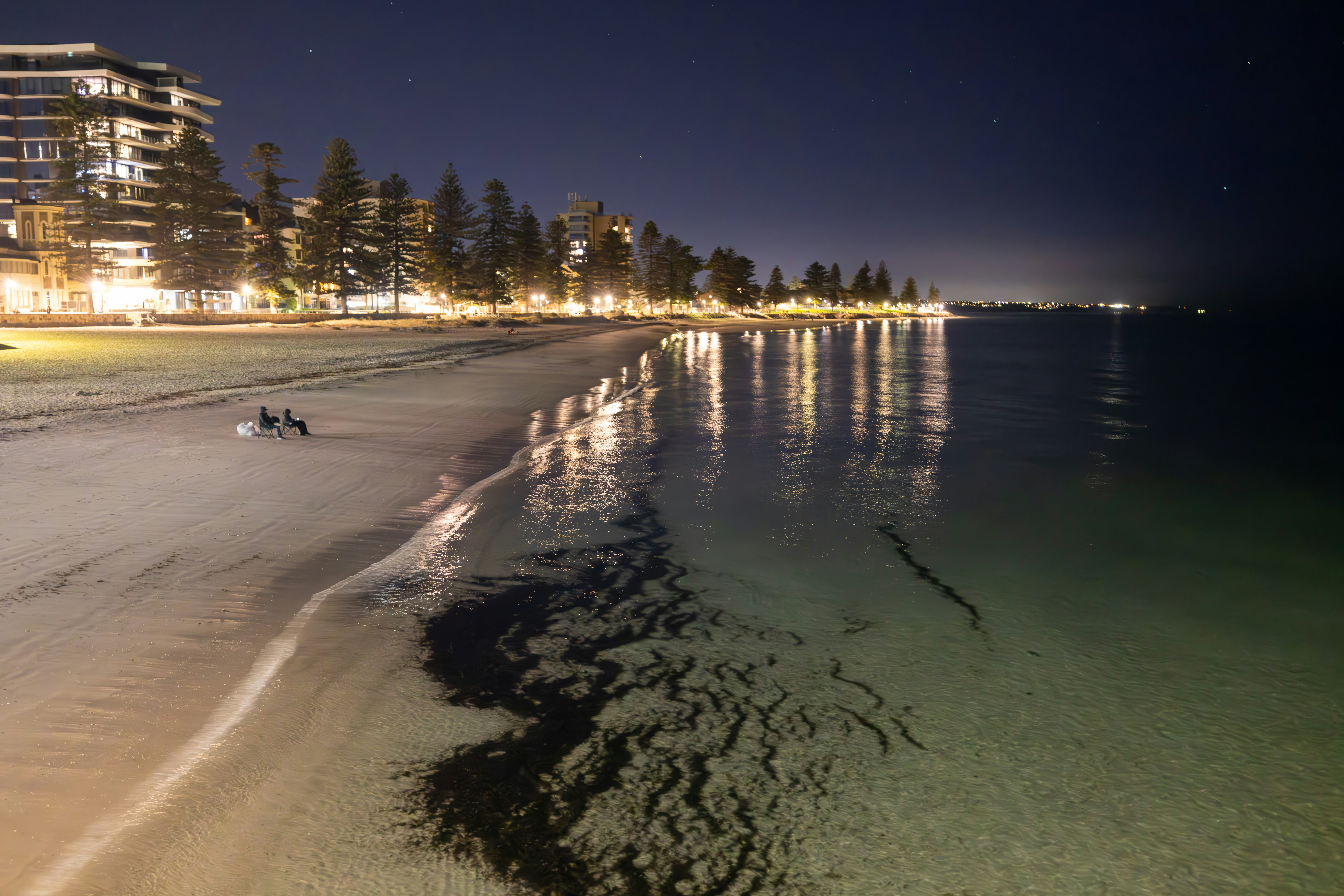 A beach at night with a building in the background