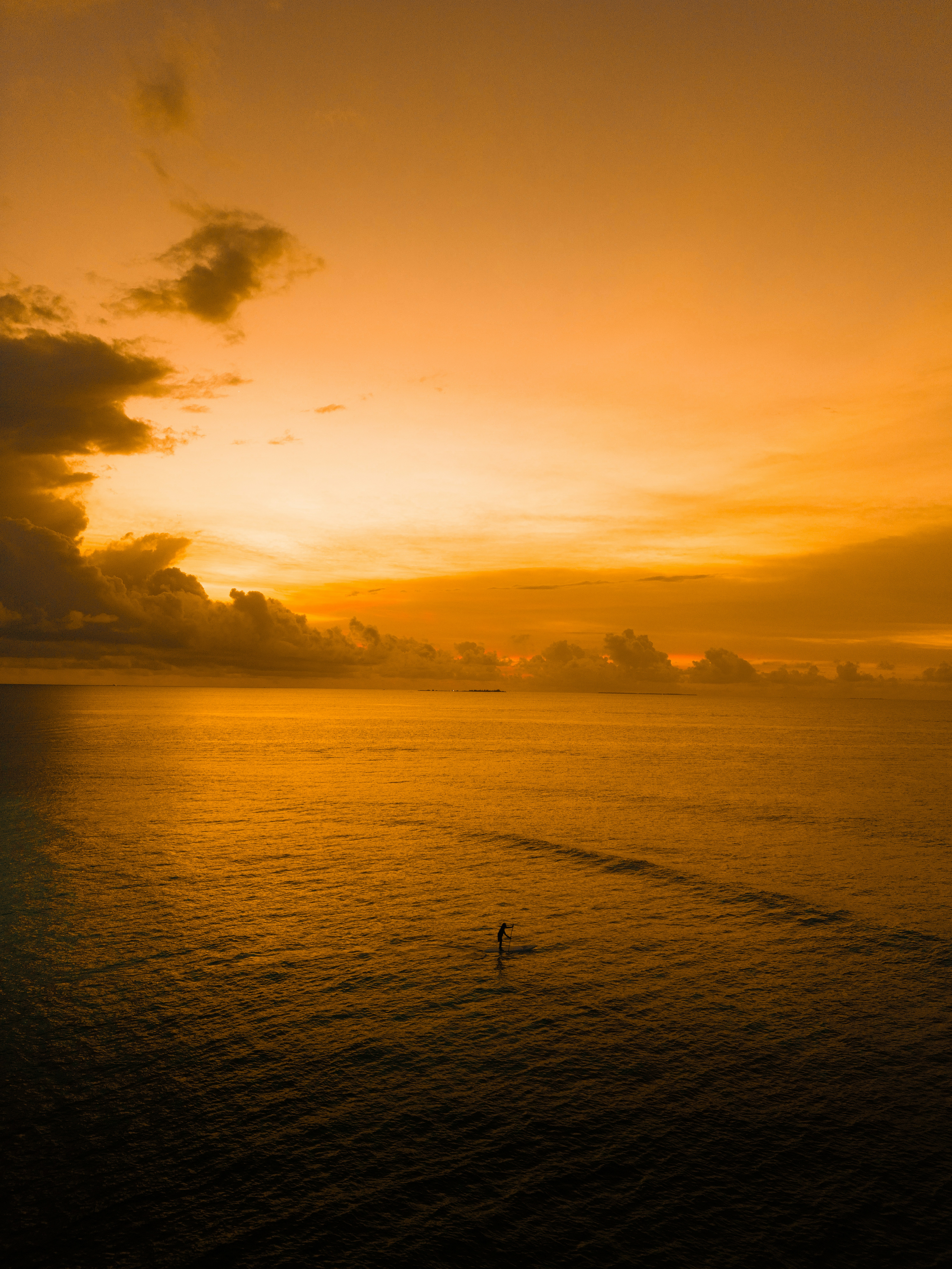 O sol está se pondo sobre o oceano com um barco na água
