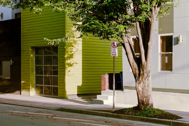 A green building with a tree in front of it