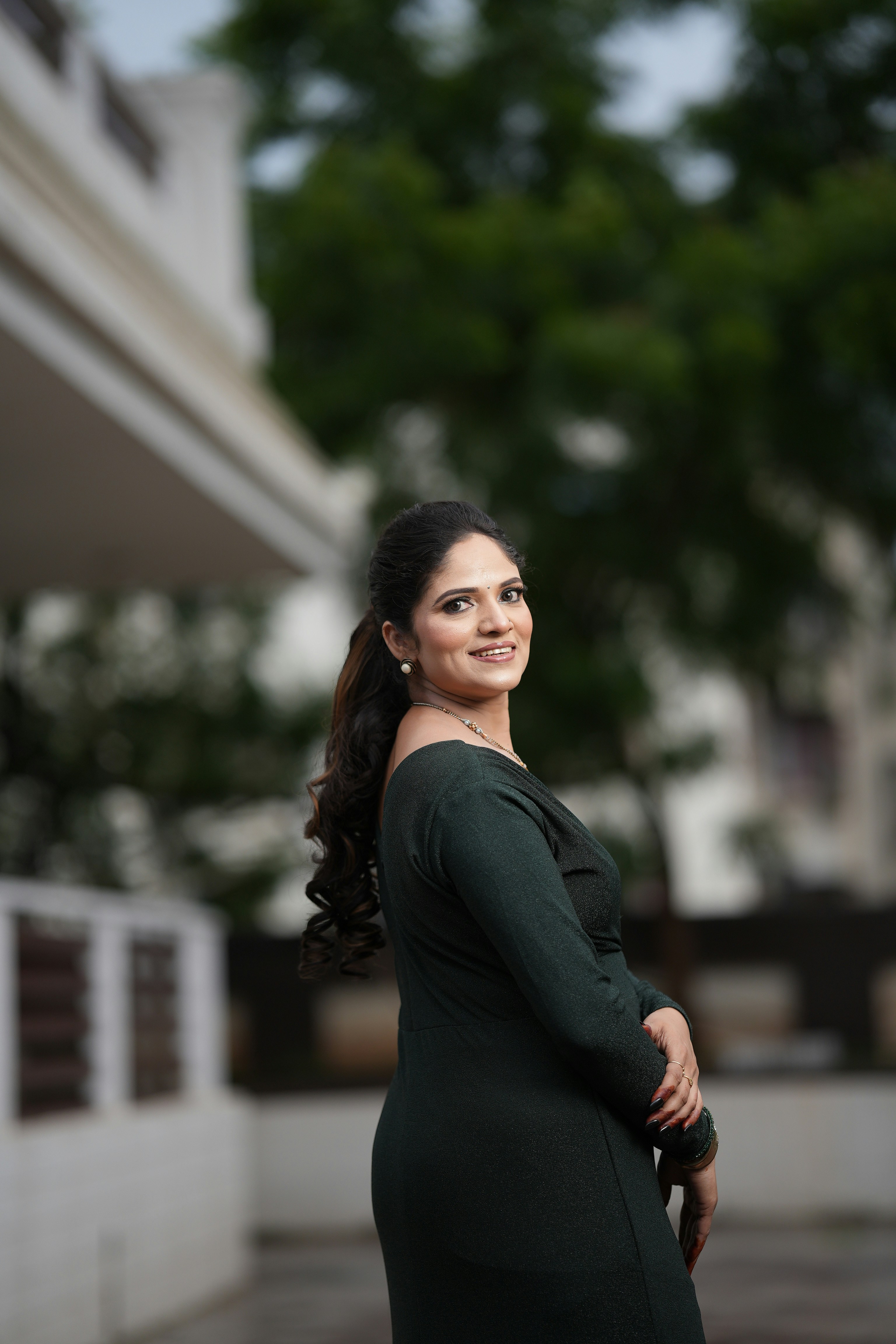A woman in a green dress standing on a sidewalk photo – Free Woman ...
