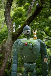 A statue of a robot in a forest