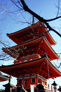 A tall red pagoda sitting under a blue sky