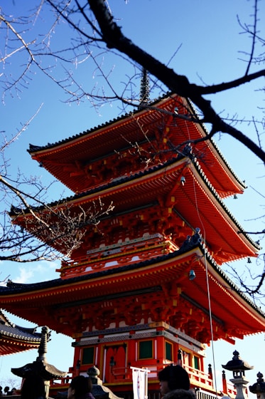 A tall red pagoda sitting under a blue sky