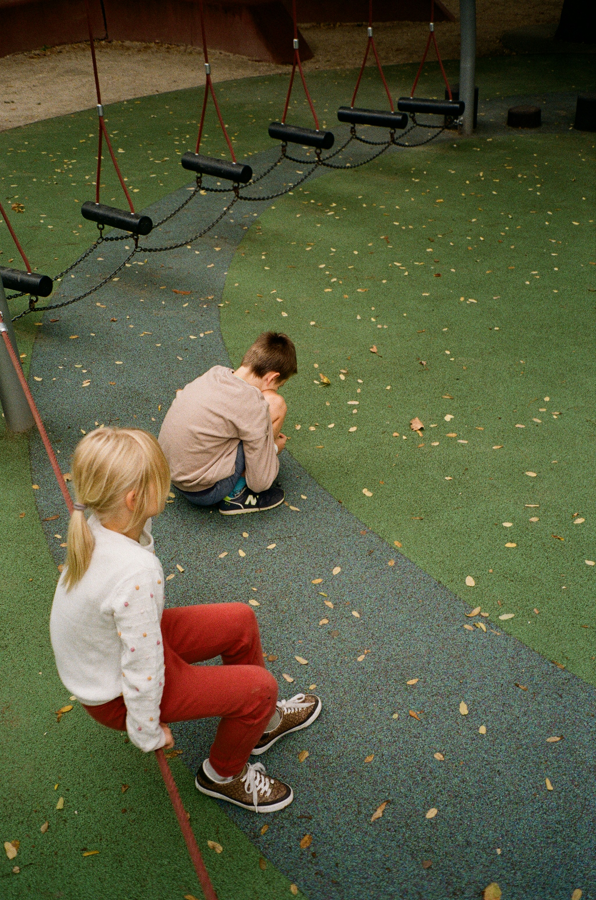 A couple of kids sitting on top of a playground