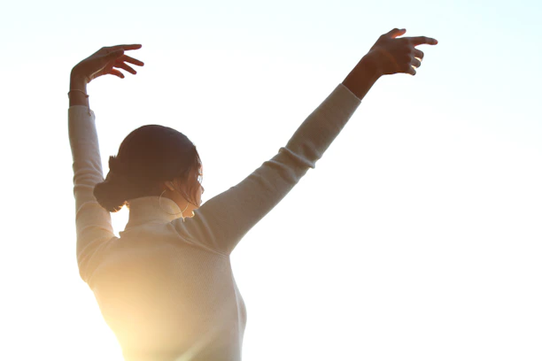 A woman reaching up to catch a frisbee