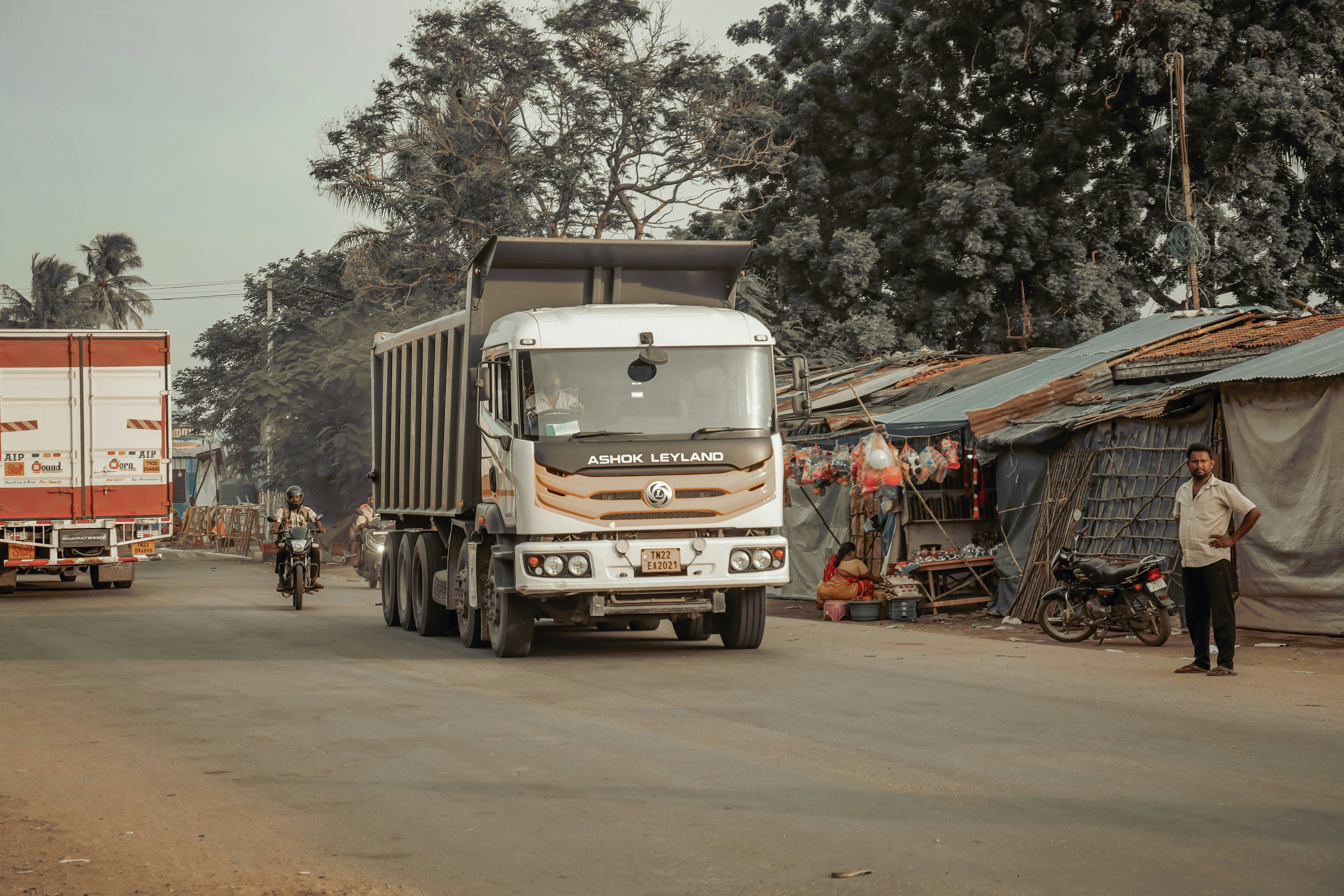 A truck driving down a street next to tents