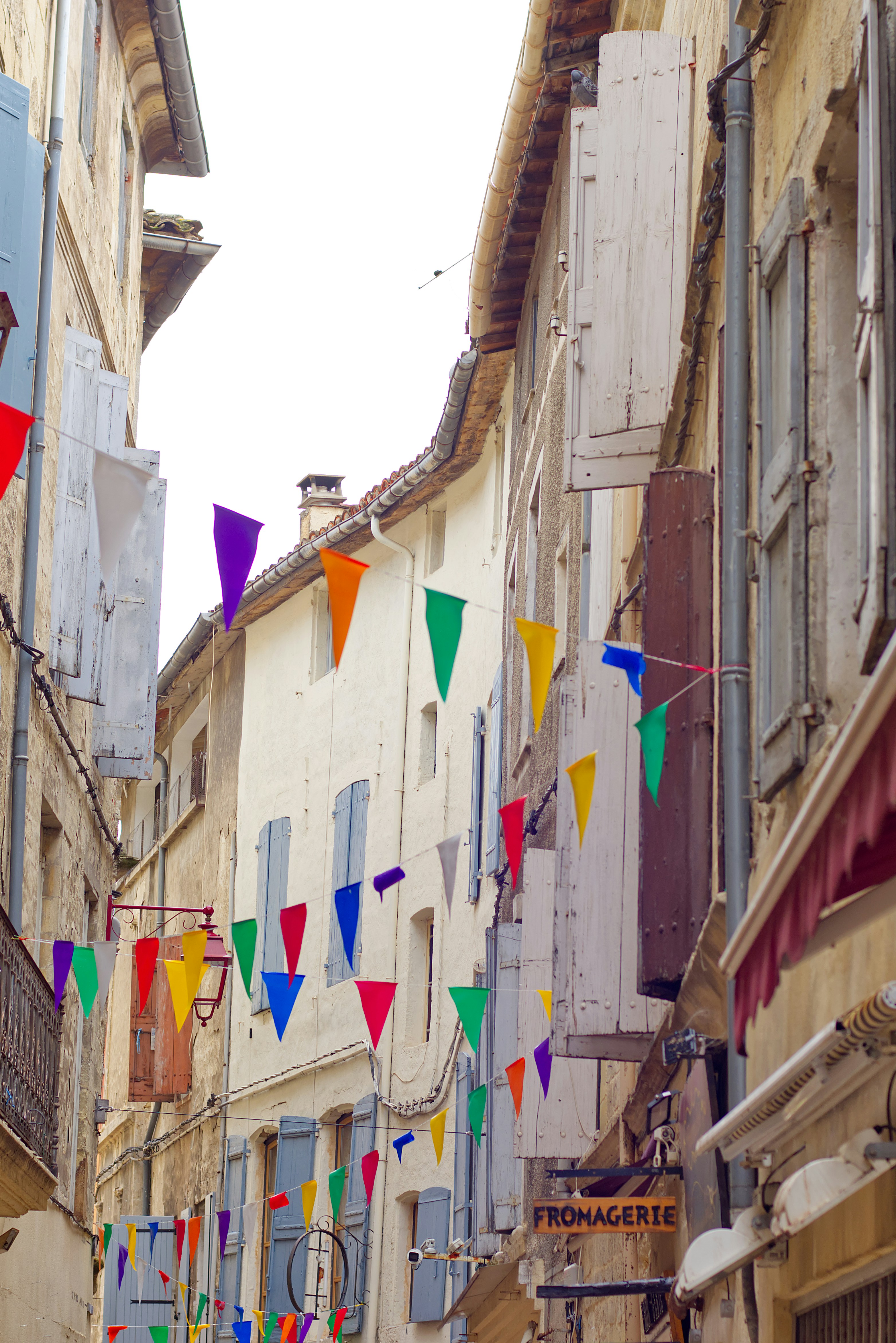 A city street with a bunch of flags hanging from the side of buildings